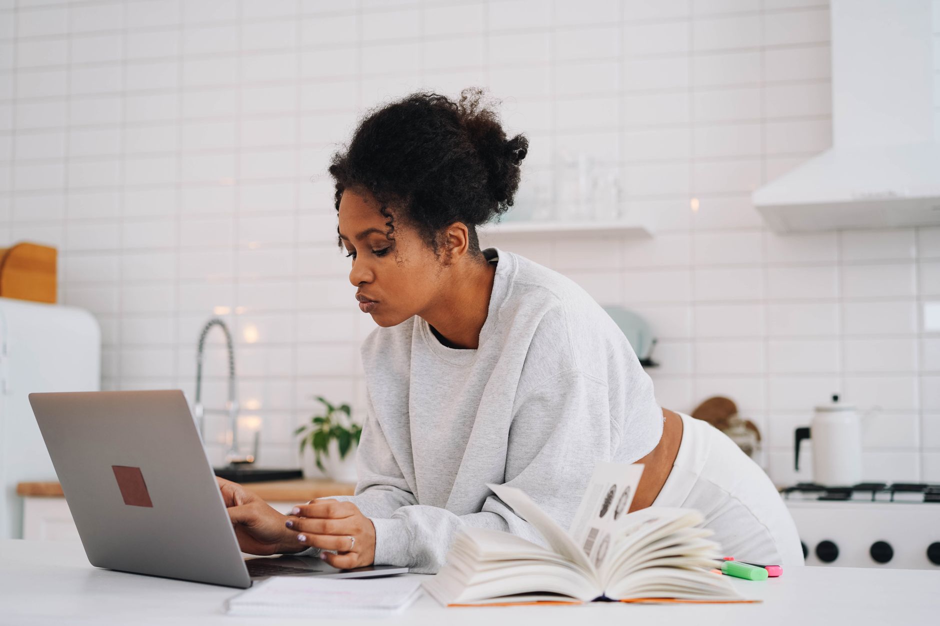 An associate-degree RN attending an online RN-to-BSN bridge class on a laptop after a hospital shift