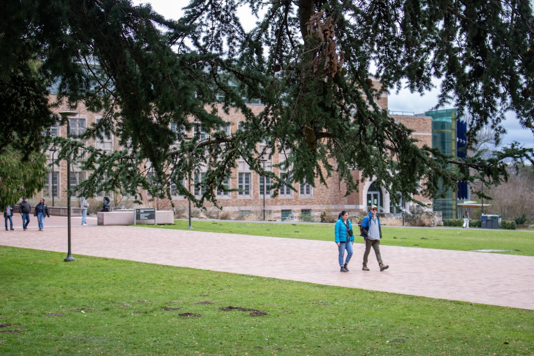 Students walking past a university building while comparing nursing programs on campus