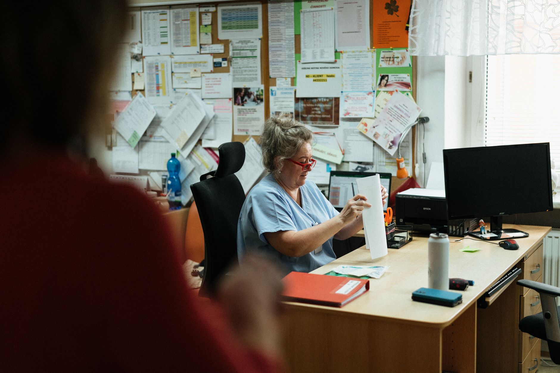 Charge nurse reviewing unit staffing and assignments at a computer