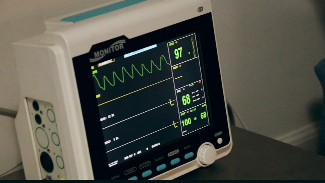 Critical-care nurse managing a ventilated ICU patient with cardiac monitoring