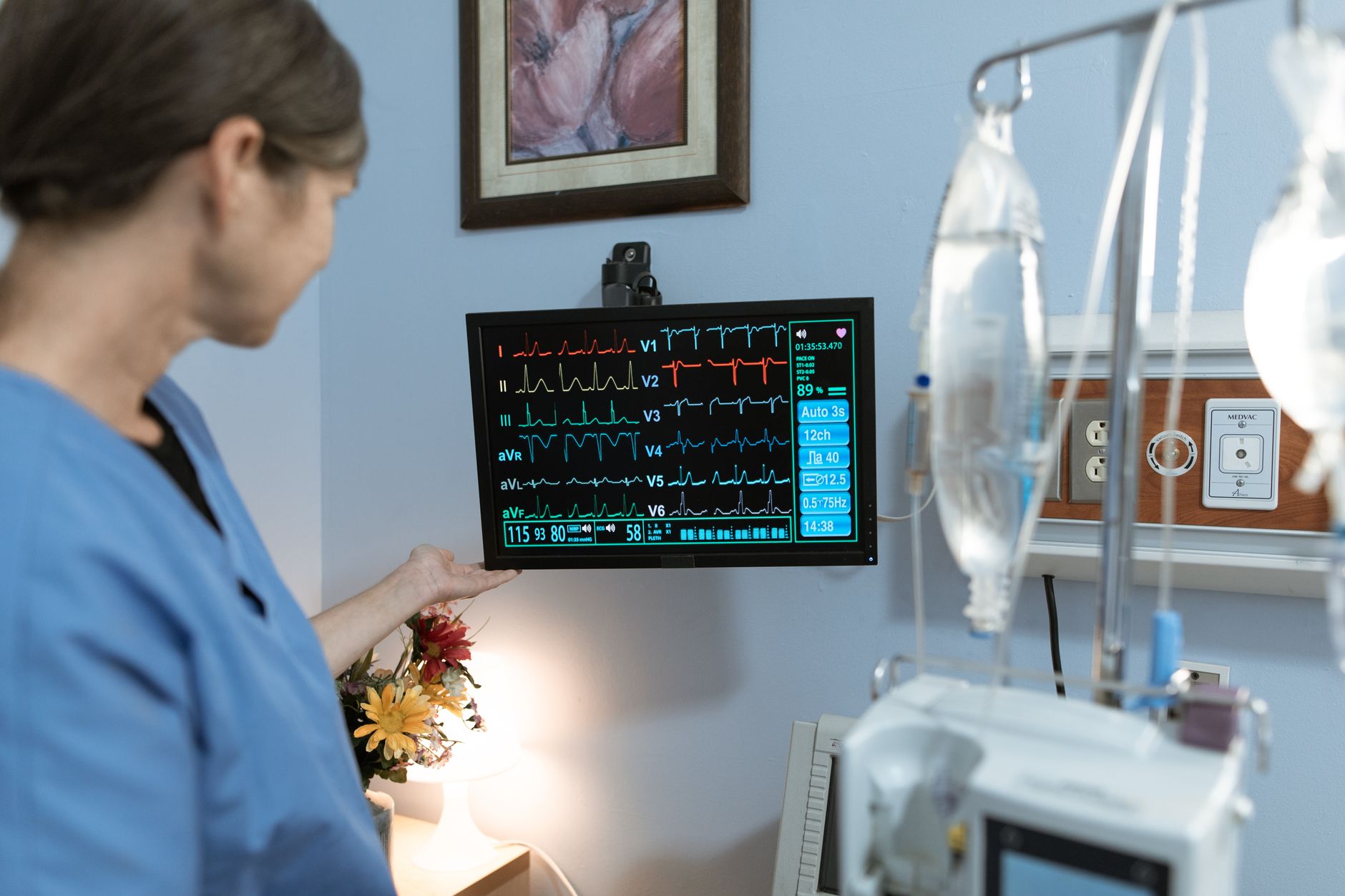 Nurse reviewing a patient chart and monitor while working through an unfolding NCLEX case study