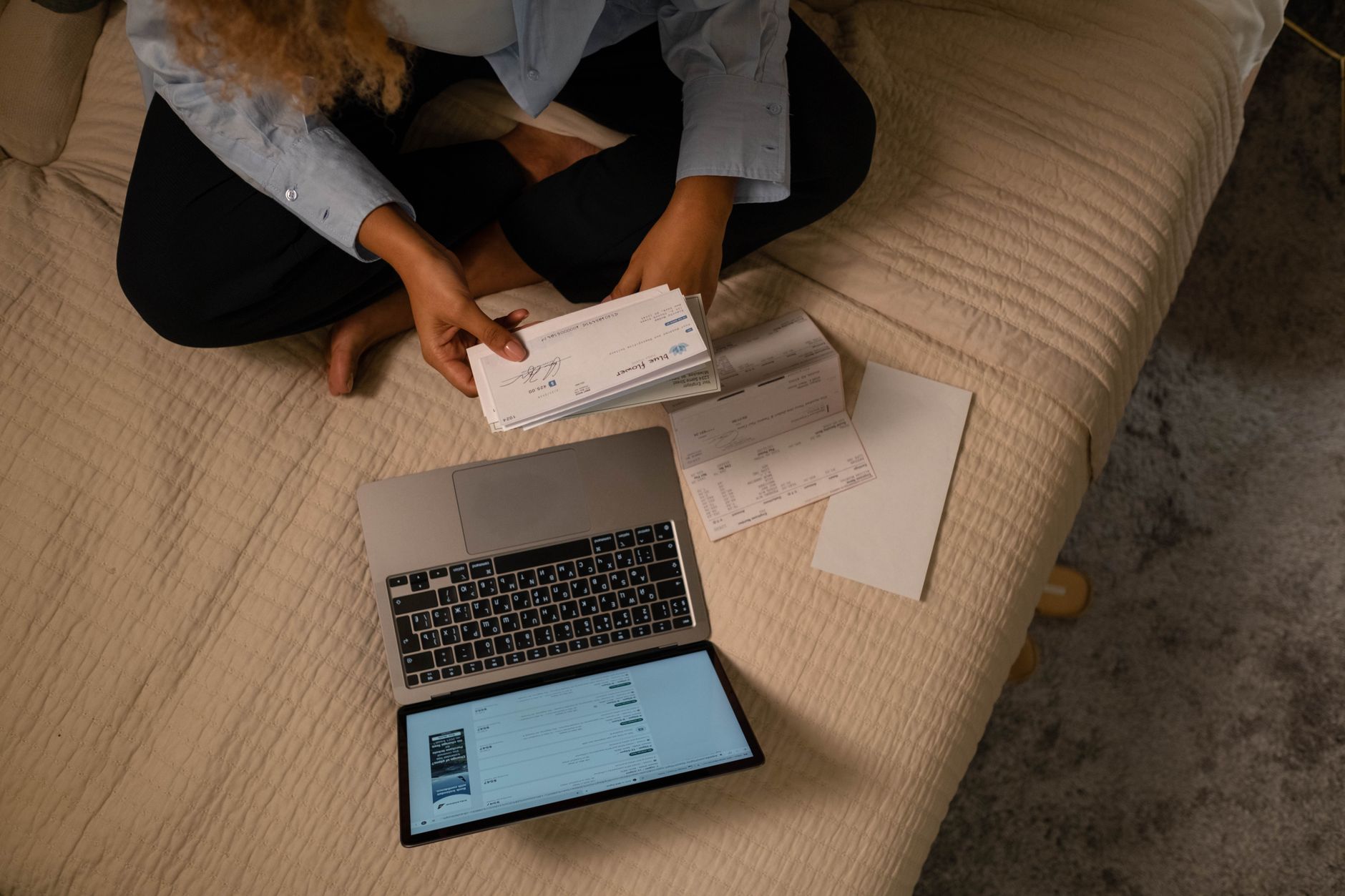 A nursing graduate anxiously checking their Pearson VUE account on a laptop after the NCLEX