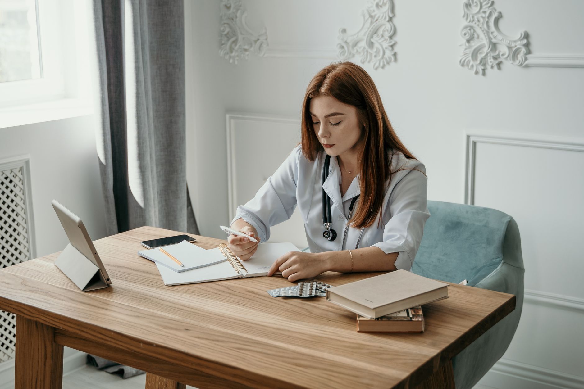 A nursing student's desk with a drug guide, a tablet showing practice questions, and a lab-values card