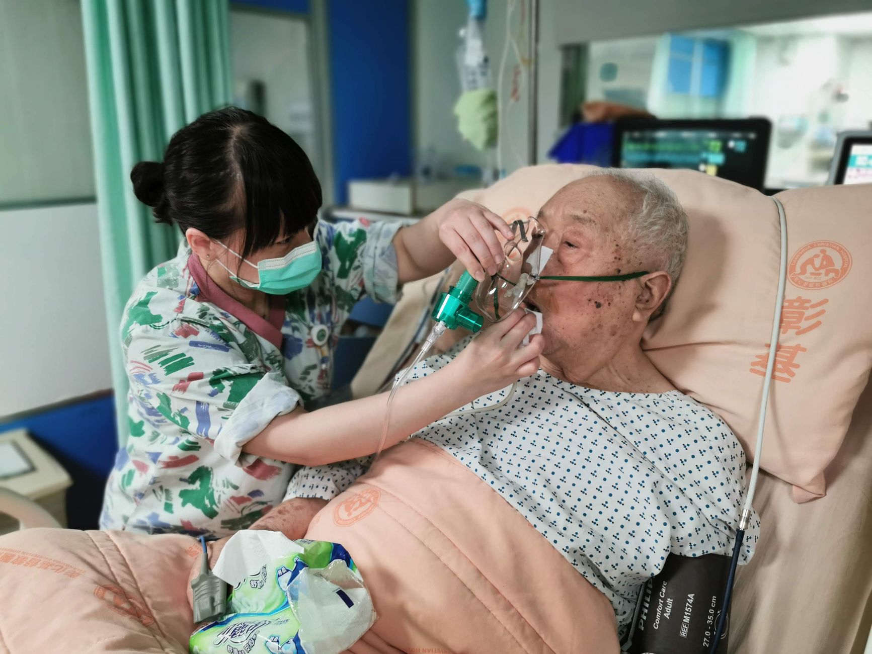 Nurse applying supplemental oxygen to a patient in acute respiratory distress