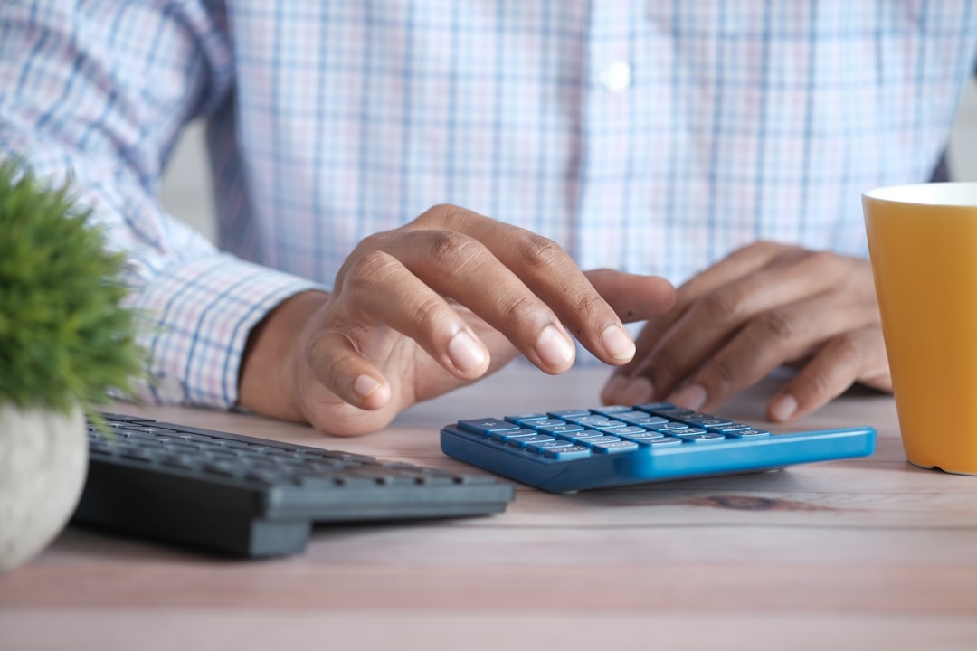 Nursing applicant using a calculator to budget the $120 ATI TEAS registration fee